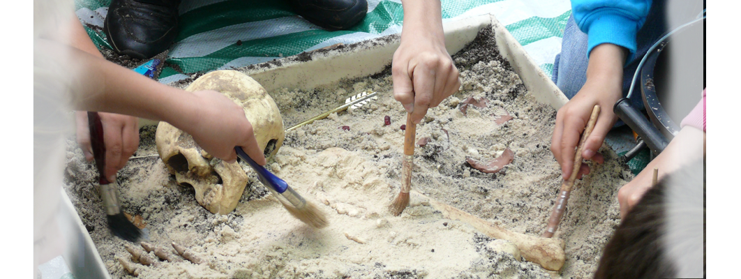 Children learning to excavate a fake skeleton